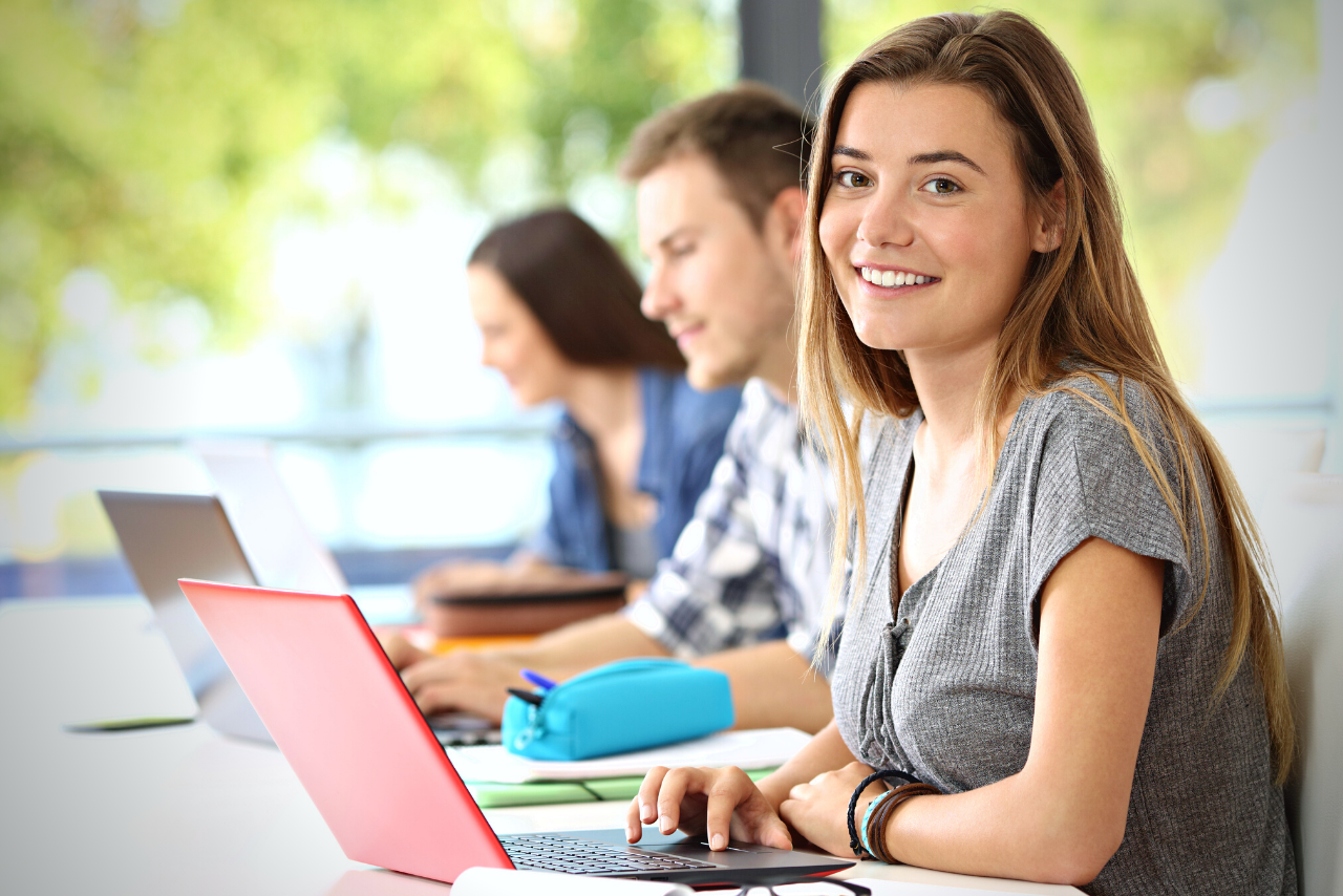 Schülerin mit Laptop in der Klasse