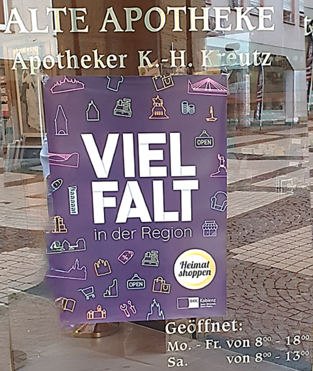 Eingangstür mit Schriftzug und Heimat Shoppen-Plakat