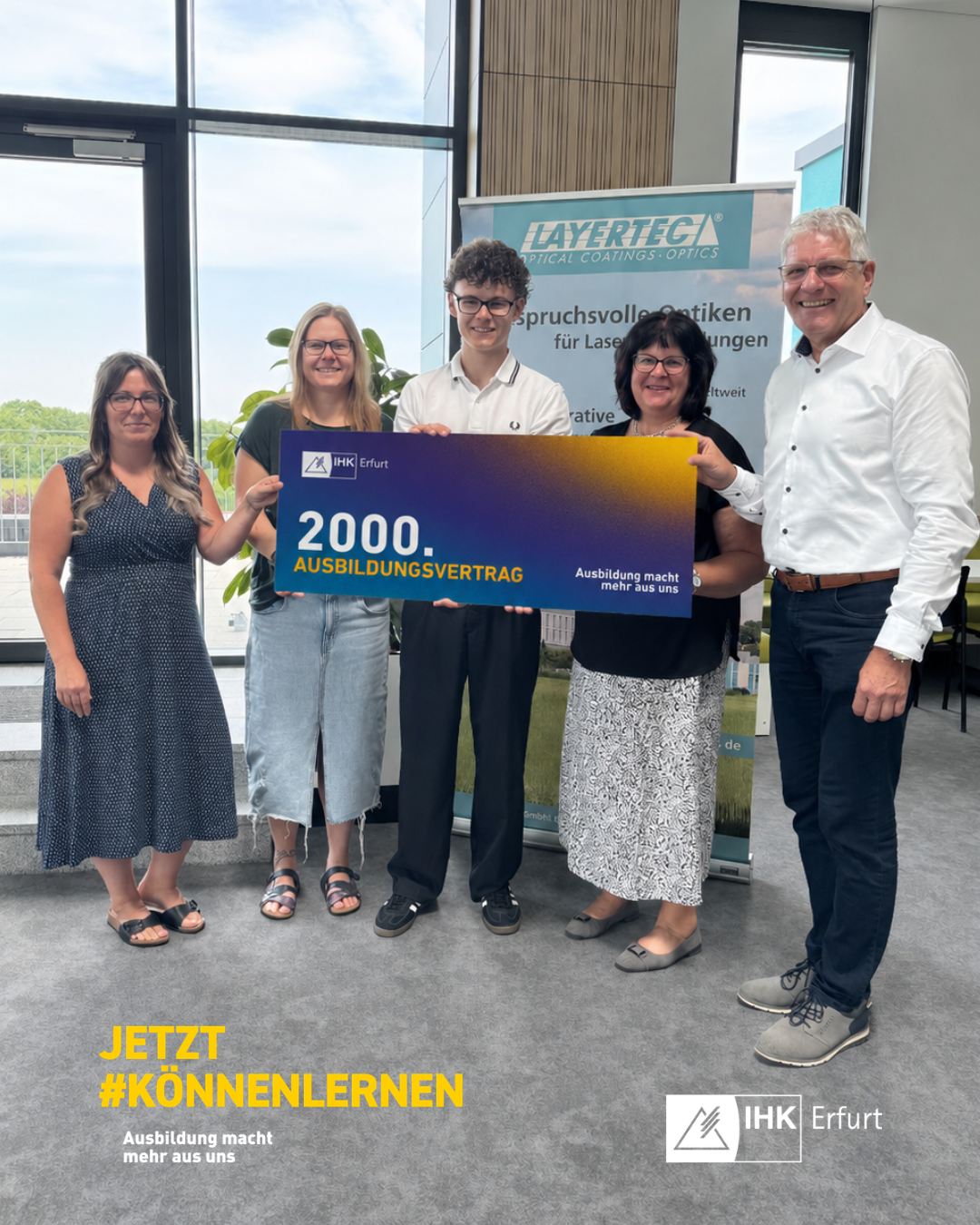 Fünf Personen bei der Übergabe einer Tafel zum 2.000. Ausbildungsvertrag bei der LAYERTEC GmbH.