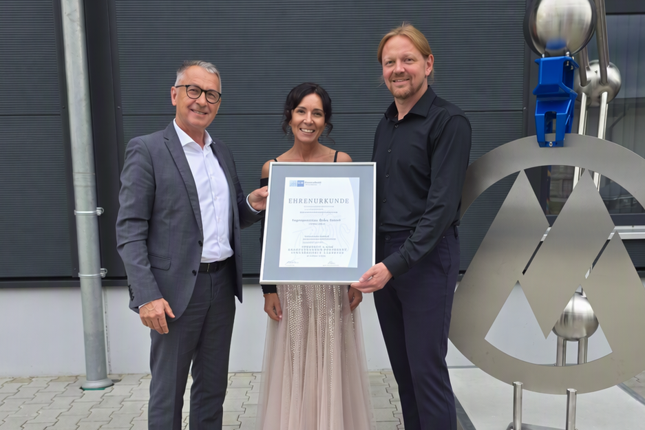 IHK-Gesch&auml;ftsstellenleiter Richard Brunner &uuml;berreicht Daniela und Heiko Muhr die Ehrenurkunde.