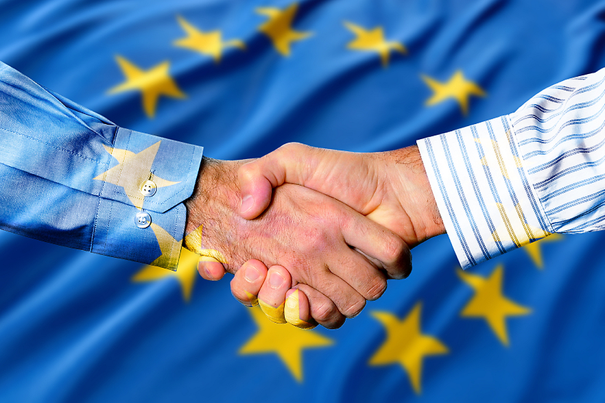 Händeschütteln über einer Europaflagge