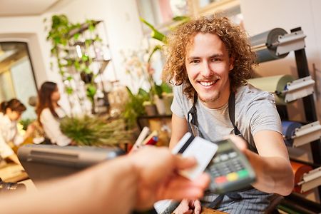 Ein Kunde zahlt bargeldlos an der Kasse eines Gartencenters