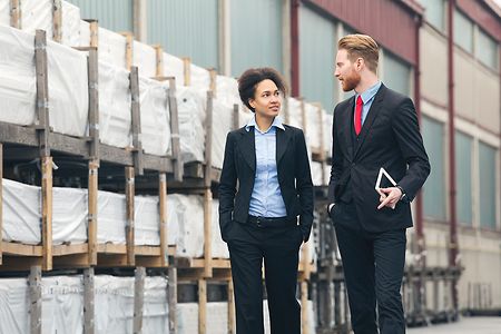 Zwei Gesch&auml;ftspartner gehen durch ein Lager