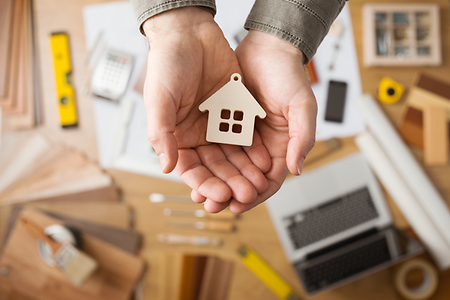kleines Holzhaus in einer Hand