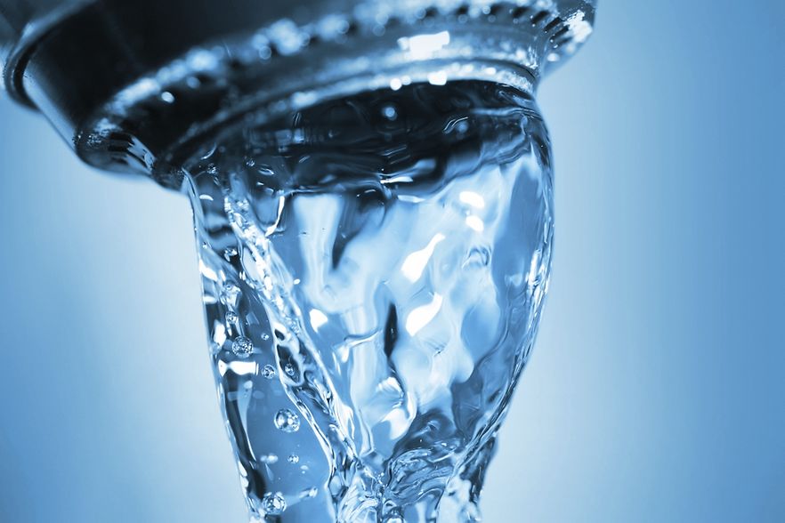 Das Bild zeigt Wasser aus dem Wasserhahn laufen.