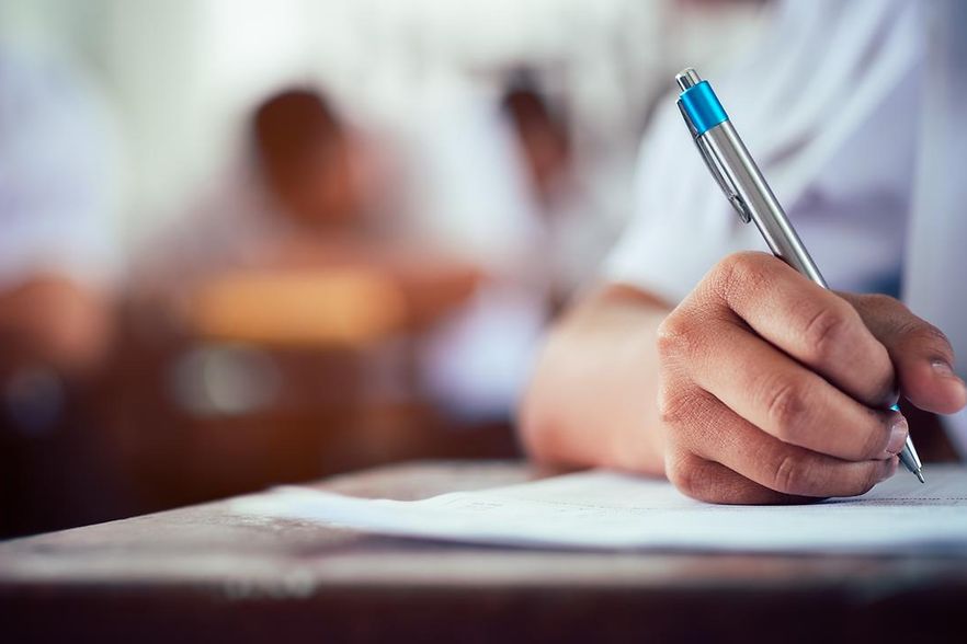 Hand h&auml;lt Stift und schreibt auf einem Blatt