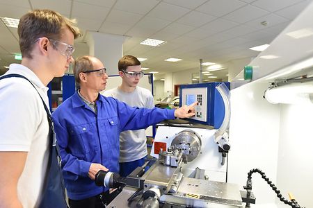 Ausbilder erkl&auml;rt Auszubildenden den Gebrauch einer Drehmaschine