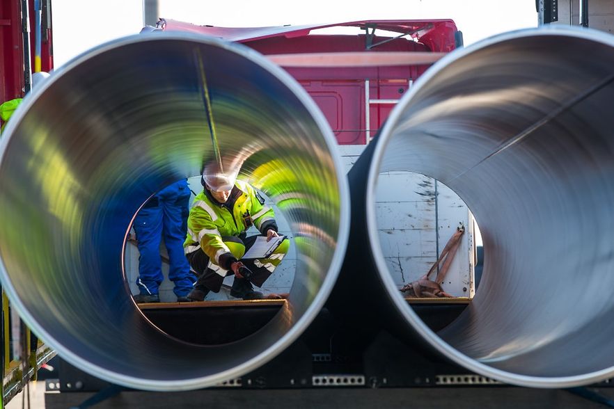 Industrierohre, Arbeiter mit Schutzbekleidung dahinter
