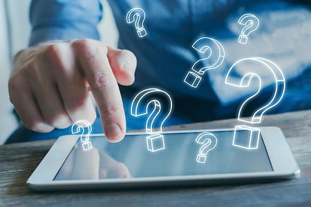 Mann mit Laptop und Fragezeichensymbolen
