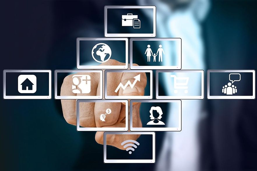 Ein Mann im Anzug zeigt auf Icons, die f&uuml;r Digitalisierung stehen.