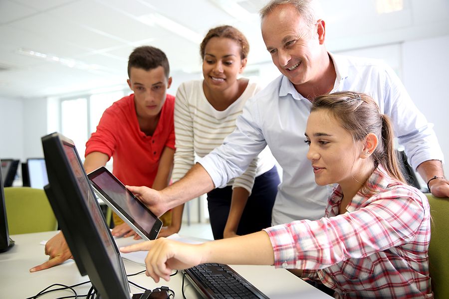Auszubildende mit ihrem Ausbilder am Computer
