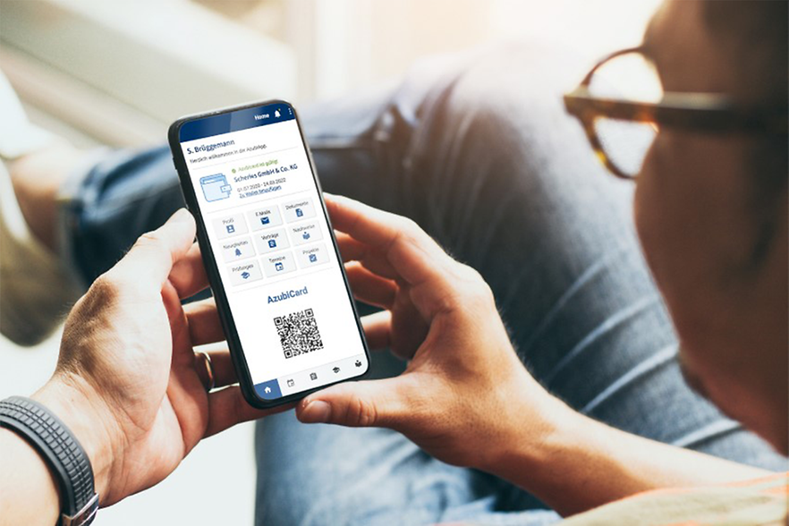 AzubiCard: GOP und Poco machen schon mit Ein Mann hat ein Handy in der Hand und schaut auf die Azubi-App