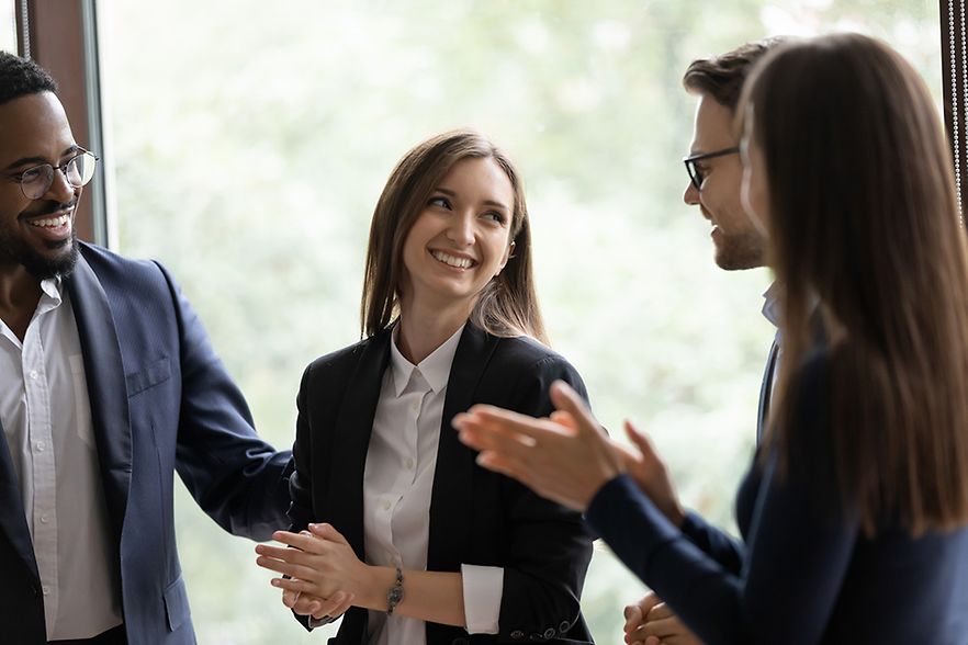 Diverse millennial colleagues meeting new female teammate in office