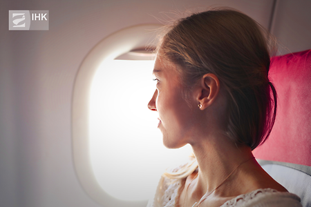 Person im Flugzeug die aus dem Fenster guckt
