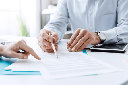 Versicherungsvertrag wird zwischen einem Geschäftsmann und einem Interessenten unterzeichnet. 