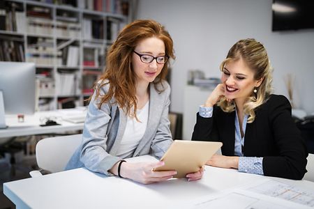 Businesswomen and architects working and talking in office
