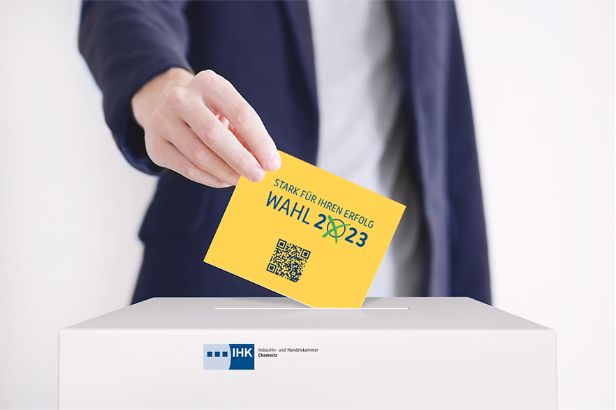 Hand eines Mannes steckt gelbe Karte in eine Wahlurne