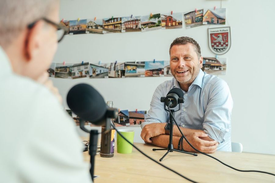 Mehrere Personen sind mit der Aufzeichnung eines Podcasts beschäftigt.
