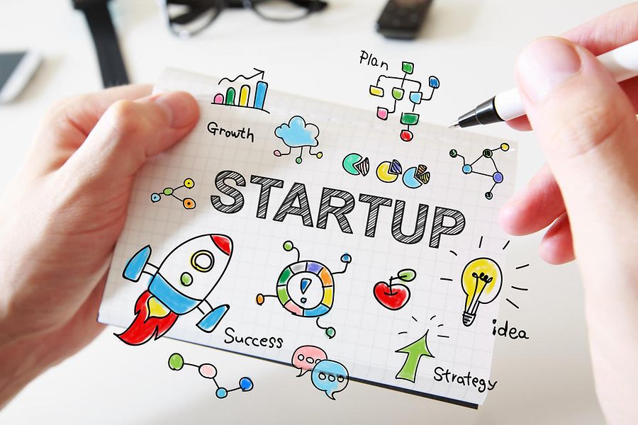 Mans hand drawing Startup concept on notebook