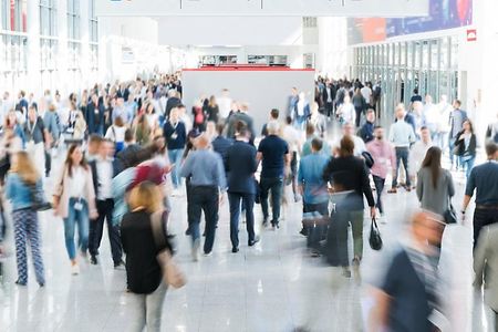 Viele Menschen in einer Messehalle