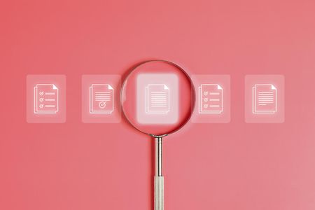 Symbole die verschiedene Arten von Textdokumenten darstellen. &Uuml;ber dem mittleren liegt eine Lupe.