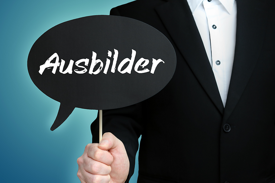 Mann h&auml;lt Karte mit "Ausbilder"-Aufschrift in der Hand. 