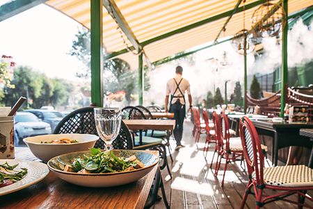 Summer terrace cafe with served table and waiter