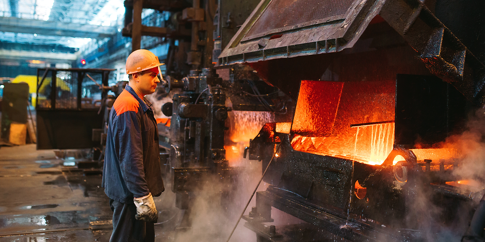 Stahlarbeiter steht vor Industrieofen