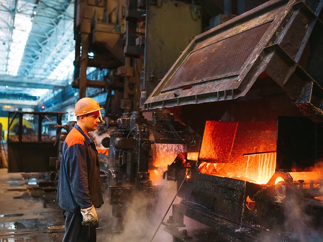 Stahlarbeiter steht vor Industrieofen