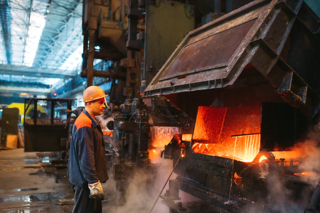 Stahlarbeiter steht vor Industrieofen