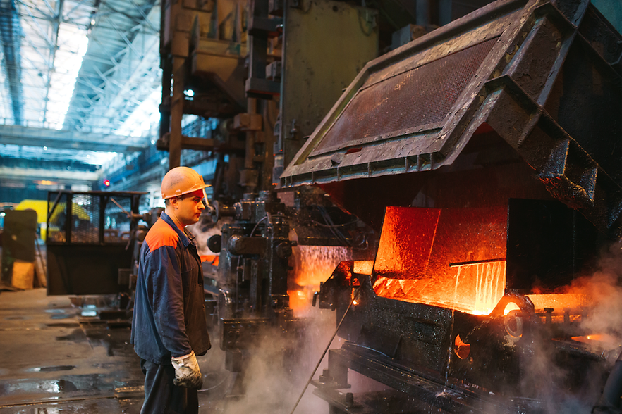 Stahlarbeiter steht vor Industrieofen