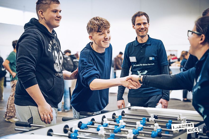 Junge Menschen stehen am Tischkicker