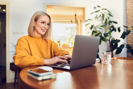 Frau sitzt vor Laptop