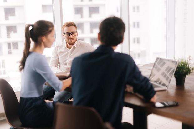 drei Personen am Tisch im Gespräch