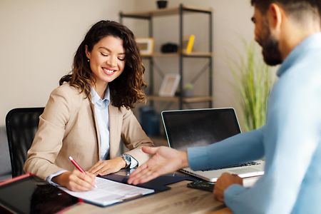 Young woman signing contracts with a manager