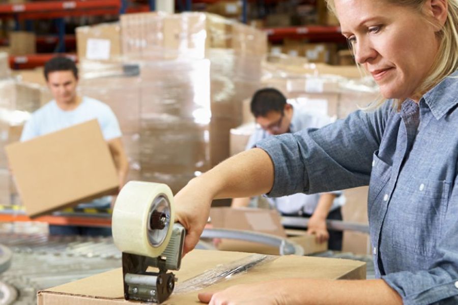 Frau im Lager verpackt Ware
