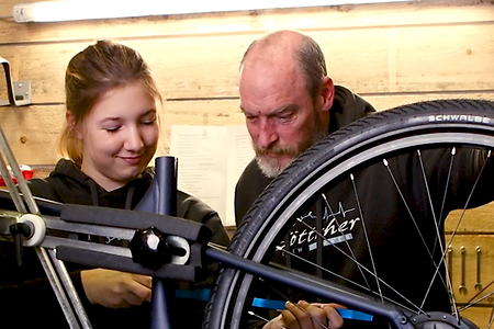 Auszubildende und Ausbilder reparieren ein Fahrrad.