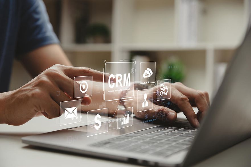 Mann am Laptop mit Symbolen zum Thema Customer Relationship Management (RRM)
