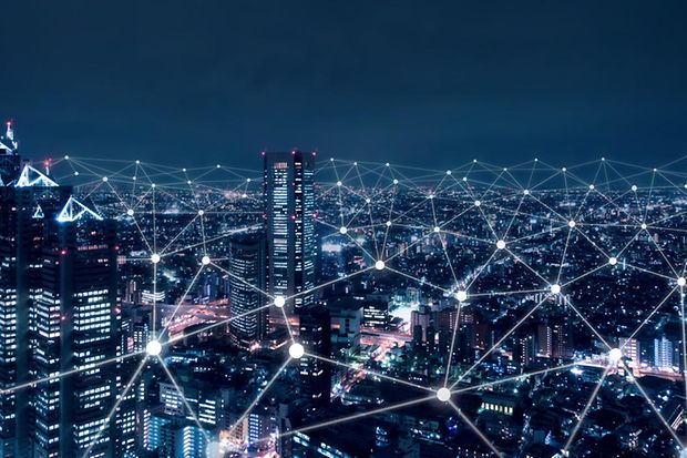 Über einer Stadt-Skyline ist ein Telekommunikationsnetzwerk visualisiert.