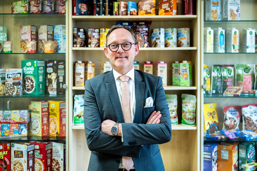 R&uuml;diger K&uuml;hl vor den DeVauGe-Produkten