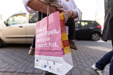 Eink&auml;uferin mit Papiert&uuml;te "Kauf in deiner Stadt, damit sie Zukunft hat"