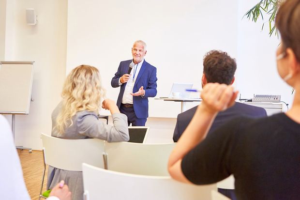 Redner gibt Präsentation bei Business Konferenz vor Publikum im Konferenzraum