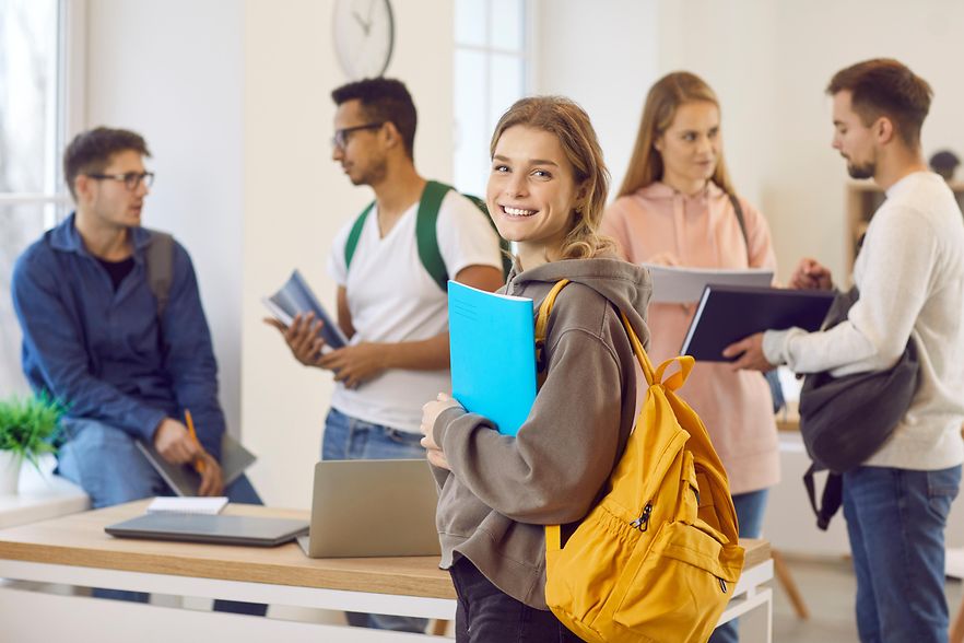Junge l&auml;chelnde Frau in einem Klassenzimmer