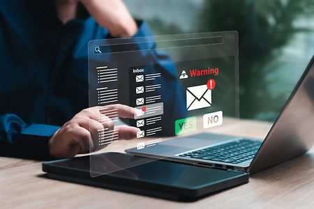 Gesch&auml;ftsmann, der am PC sitzt und bei E-Mail-Betrug &bdquo;Ja&ldquo; oder &bdquo;Nein&ldquo; ausw&auml;hlt