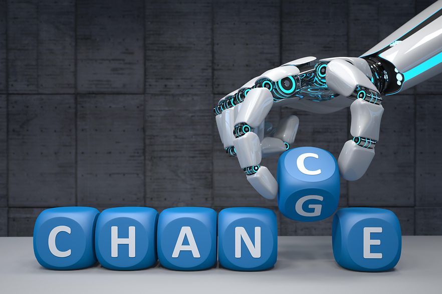 Eine Roboterhand mit blauen Bausteinen, die die Aufschrift "Change" zeigen