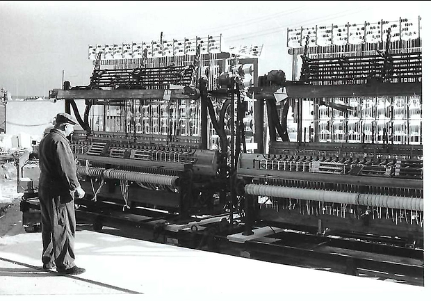 Das Foto von einem Webstuhl bei Glücksband Roth ist mit 1970 datiert.
SW-Foto von einem älteren Mann vor einem riesigen Webstuhl