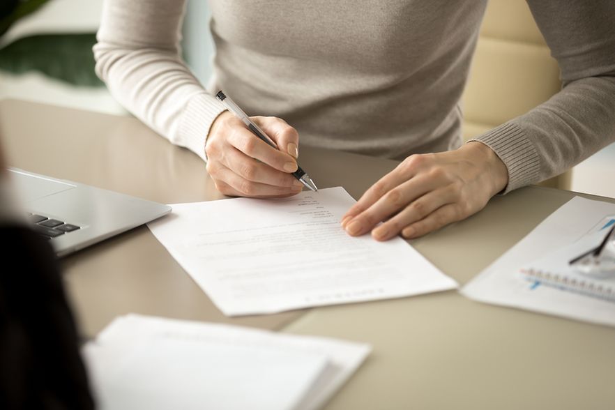 Woman,Signing,Document,,Focus,On,Female,Hand,Holding,Pen,,Putting