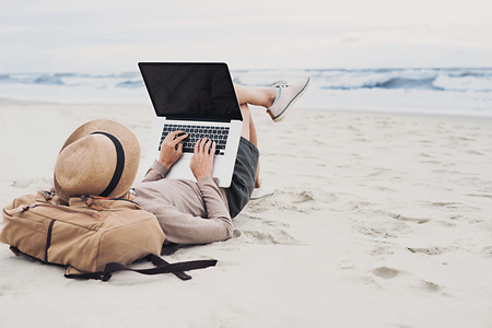 frau mit laptop am strand
