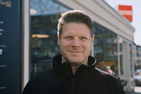 Ren&eacute; Irrgang steht vor einem REWE-Markt in K&ouml;ln