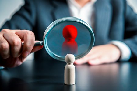 Businessman,Using,Magnifying,Glass,Look,At,Company,Personnel,Looking,For